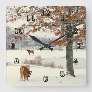 Pony and horse in snow by a lake clock