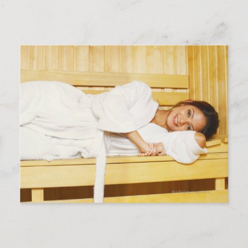 Portrait of a young woman lying in a sauna postcard