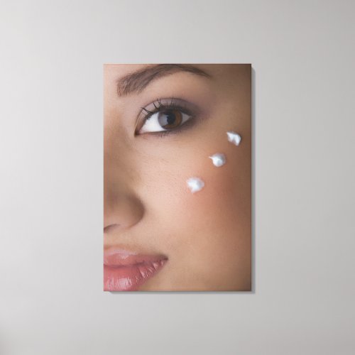 Portrait of a young woman with cream on her canvas print
