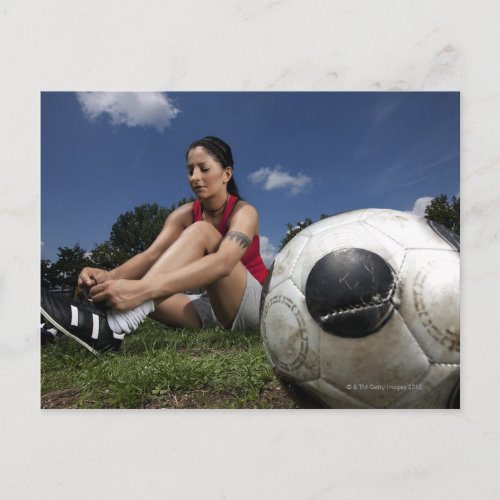 portrait of female football player tying her postcard