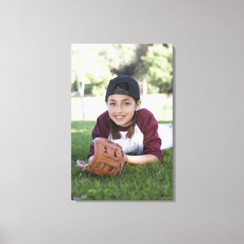 Portrait of girl lying on ground with baseball canvas print