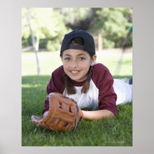 Portrait of girl lying on ground with baseball poster