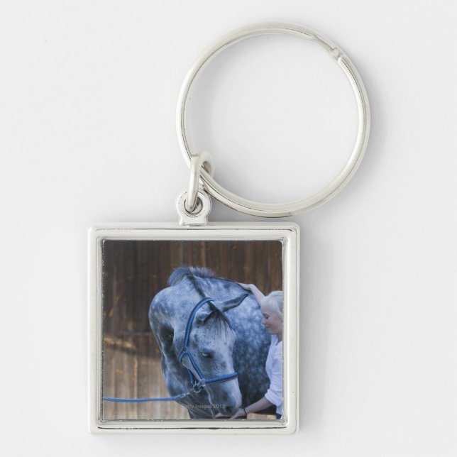 portrait of young girl holding white horse keychain (Front)
