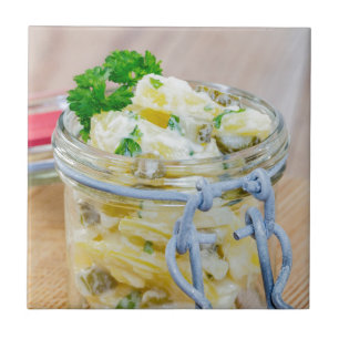 Potato salad in a jar on wooden ceramic tile