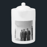 President John Kennedy & Brothers American Camelot Teapot<br><div class="desc">The sun beat down on the three Kennedy brothers as they stood beneath the familiar white portico of the White House. President John F. Kennedy, the eldest, leaned against a pillar, a wry smile playing on his lips. His younger brothers, Robert and Ted, stood beside him, their faces a mix...</div>