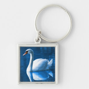 Pretty white swan floating on a blue lake keychain