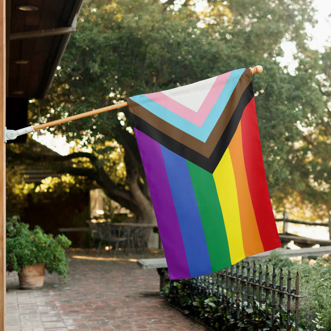 Colorful official LGBTQIA+ pride flag displayed in an outdoor setting. 