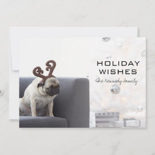 Pug dog wearing reindeer horns on couch holiday card
