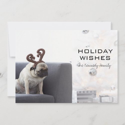Pug dog wearing reindeer horns on couch holiday card