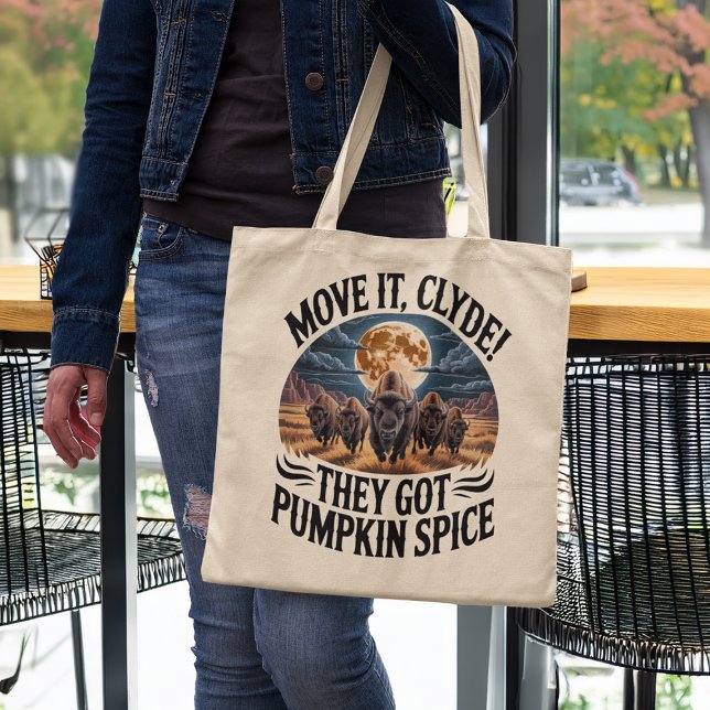 Pumpkin Spice Coffee Funny Bison Stampede Tote Bag (woman in a coffee shop holding funny pumpkin spice humor tote bag)