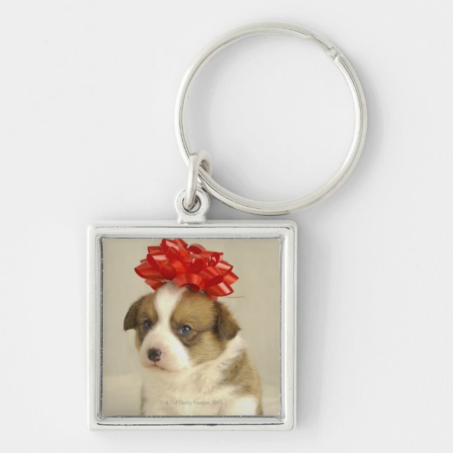 Puppy wearing a red bow keychain (Front)