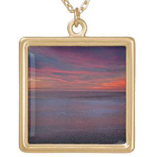 Purple-colored sunrise on ocean shore gold plated necklace