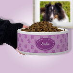 Purple Dog Paws Pattern With Custom Name Bowl<br><div class="desc">Purple dog paw print pattern background with a darker purple badge that has a personalizable text area for the name of the pet. The font is a lovely script font in white color.</div>