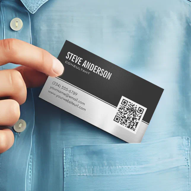 A person's hand can be seen placing a magnetic black and white business card in a breast pocket.
