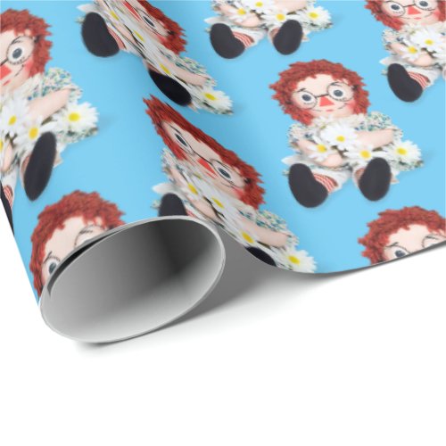 Rag doll with daisies on blue wrapping paper