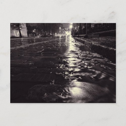 Rain water flowing on a cobblestone street postcard