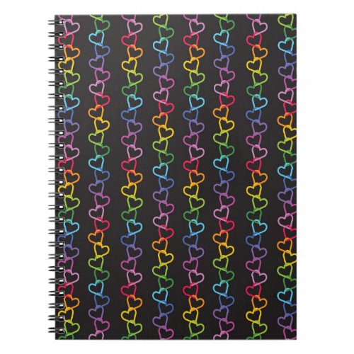 Rainbow colored linked love hearts on black notebook