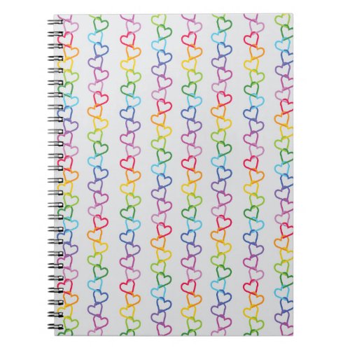 Rainbow colored linked love hearts on white notebook