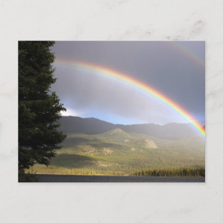 Rainbow over water against mountains postcard