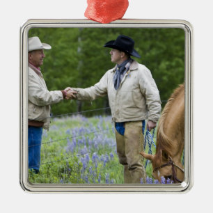 Ranchers shaking hands across the fencing in metal ornament