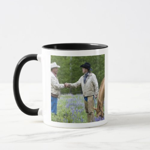 Ranchers shaking hands across the fencing in mug