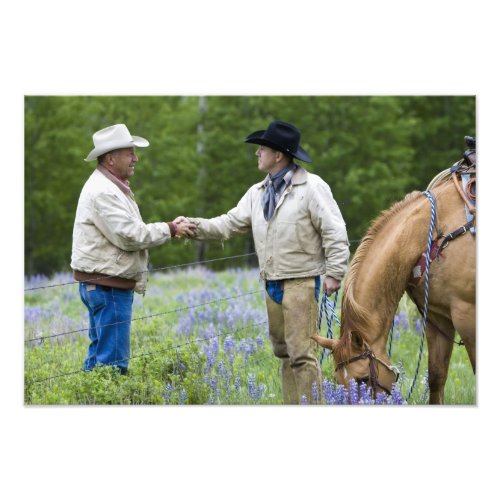 Ranchers shaking hands across the fencing in photo print