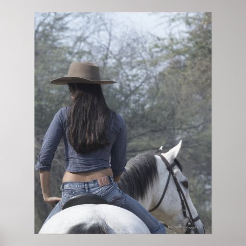 Rear view of a woman riding a horse poster