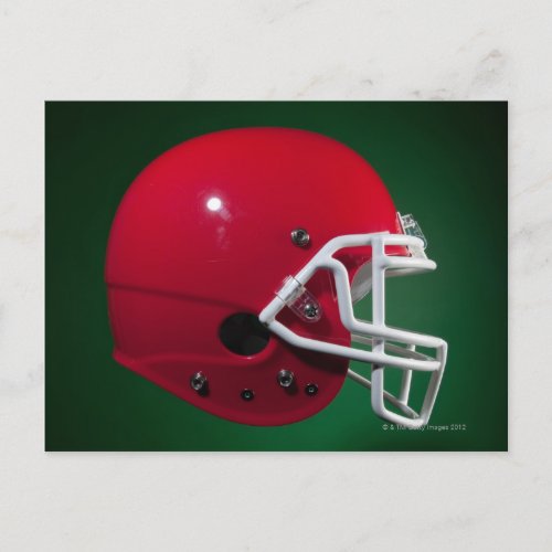 Red American football helmet on green background Postcard