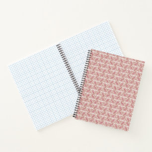 Red and pink textiles laid over a patterned rug wi notebook