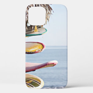 Red and white surfboard in brown wooden rack iPhone 12 case