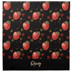 Red apples and leaves on black cloth napkin
