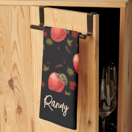 Red apples and leaves on black kitchen towel