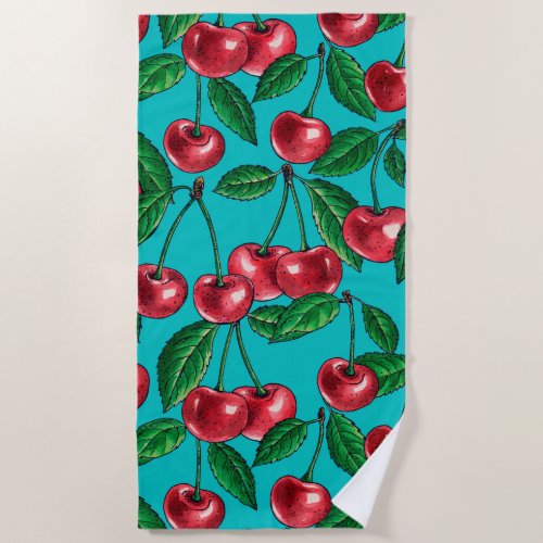 Red cherries on turquoise beach towel
