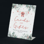 Red Christmas Santa Baby Shower Cards and Gifts Pedestal Sign<br><div class="desc">The Red Santa Gender Neutral Santa Baby Clothes Christmas Baby Shower Cards and Gifts Sign adds the perfect blend of holiday charm and organization to your festive baby shower! Featuring delicate red snowflakes, adorable Santa-themed baby clothes, and soft touches of eucalyptus greenery, this sign warmly directs guests to leave their...</div>