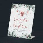 Red Christmas Santa Baby Shower Cards and Gifts Pedestal Sign<br><div class="desc">The Red Santa Gender Neutral Santa Baby Clothes Christmas Baby Shower Cards and Gifts Sign adds the perfect blend of holiday charm and organization to your festive baby shower! Featuring delicate red snowflakes, adorable Santa-themed baby clothes, and soft touches of eucalyptus greenery, this sign warmly directs guests to leave their...</div>