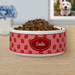 Red Dog Paws Pattern With Custom Name Bowl<br><div class="desc">Red dog paw print pattern background with a darker red badge that has a personalizable text area for the name of the pet. The font is a lovely script font in white color.</div>
