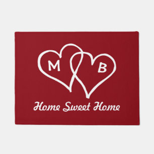 Red door mat with interlocking hearts and initials