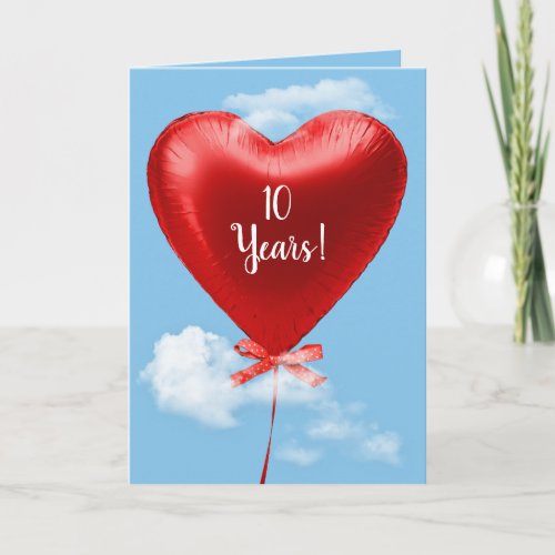 Red heart balloon in clouds for 10th anniversary card