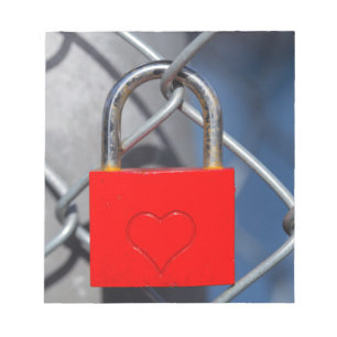 Red heart lock on fence notepad