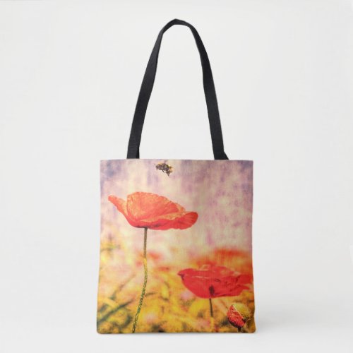 Red poppies and a bumble bee in a summer meadow tote bag