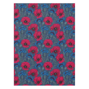 Red poppies and blue cornflowers on blue tablecloth