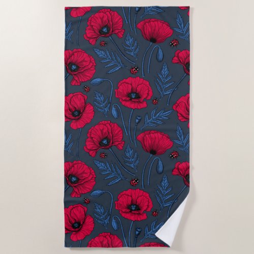 Red poppies and ladybugs on dark blue blue beach towel