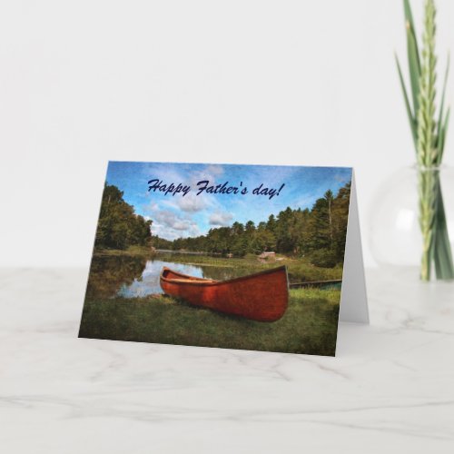 Red rustic canoe on the bank of the lake card