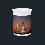 Red Sky for Space Shuttle Atlantis Launch Beverage Pitcher<br><div class="desc">The crisp morning air was electric with anticipation as the first rays of dawn painted the sky a fiery red. The colossal white silhouette of the Space Shuttle Atlantis dominated the launchpad, dwarfed only by the immensity of the moment. A collective gasp rippled through the crowd as plumes of fire...</div>