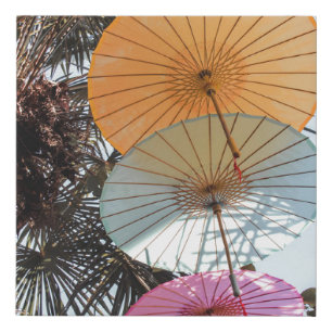 Red umbrella on green tree faux canvas print