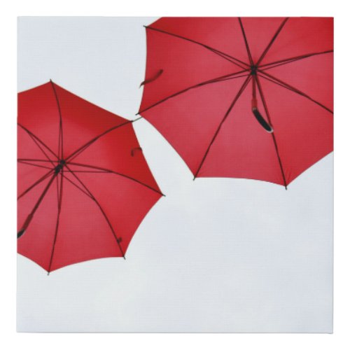 Red umbrellas hanging in the air faux canvas print