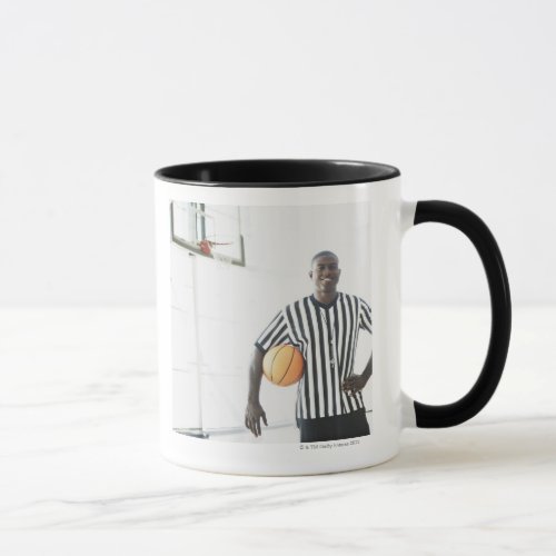 Referee holding basketball on court mug