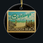 Rehoboth Beach Vintage Travel Ceramic Ornament<br><div class="desc">This Greetings From Rehoboth Beach vintage postcard design features a sandy beach with a beautiful turquoise ocean water and above the sea,  a blue sky with billowy white clouds. In vintage travels style.</div>