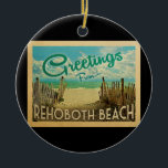 Rehoboth Beach Vintage Travel Ceramic Ornament<br><div class="desc">This Greetings From Rehoboth Beach vintage postcard design features a sandy beach with a beautiful turquoise ocean water and above the sea,  a blue sky with billowy white clouds. In vintage travels style.</div>