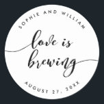 Relax Script Love is Brewing Wedding Favor Classic Round Sticker<br><div class="desc">Wedding sticker featuring the words "Love is Brewing" in a relax cursive script in black against a white background. Personalize it by replacing the placeholder text. For more options such as to change the font and it's size/color, expand /contract curve or the spacing between letters click the "Customize" button. *Please...</div>